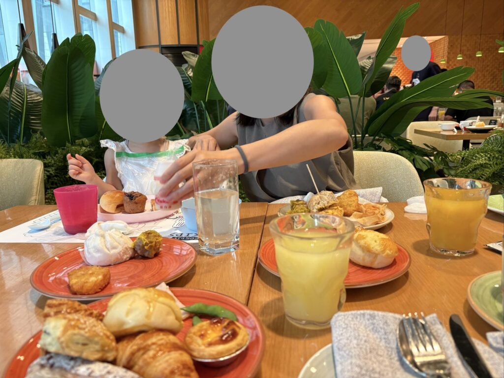朝食の席の使い捨てエプロンと子ども用コップ