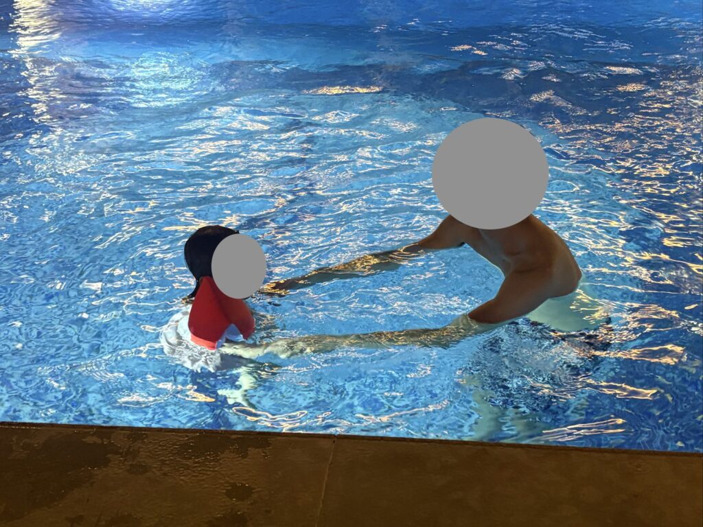 ホテルのプールで遊ぶ娘と夫