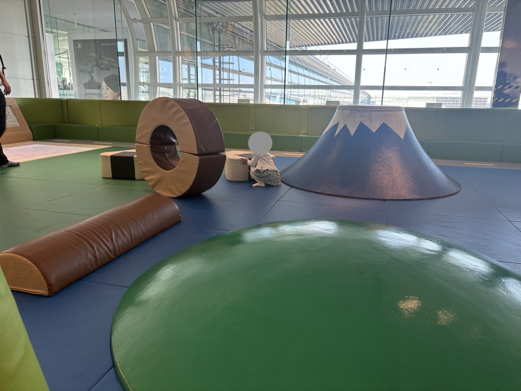 羽田空港の共用キッズスペース。富士山の形をした遊具とマットが敷かれた床