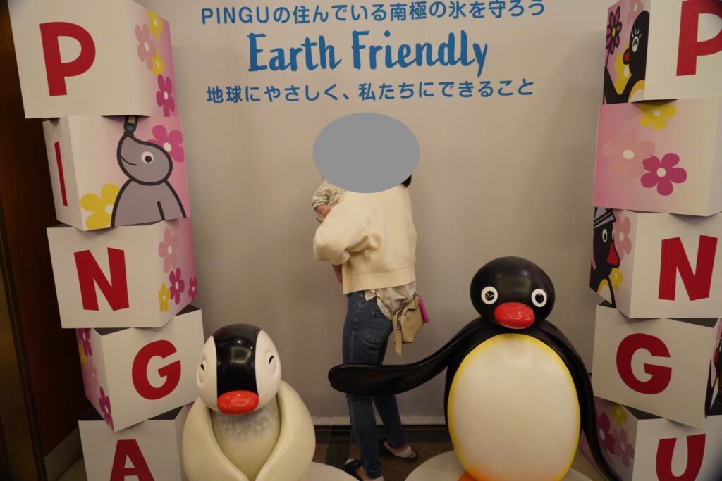 ピングーの展示の前で娘を抱っこする