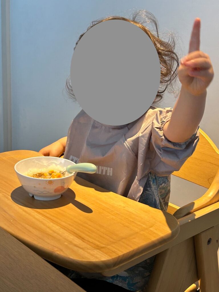 ハイチェアに座って朝食を食べる娘