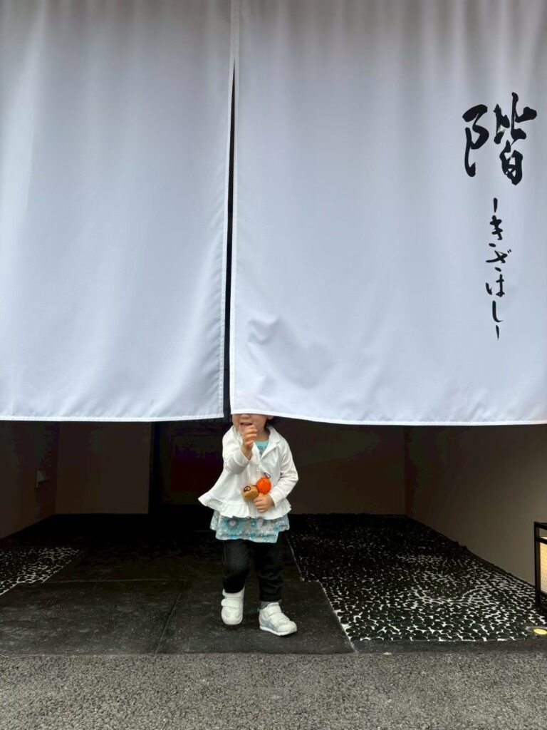 鮨 階ののれんの前に立つ娘
