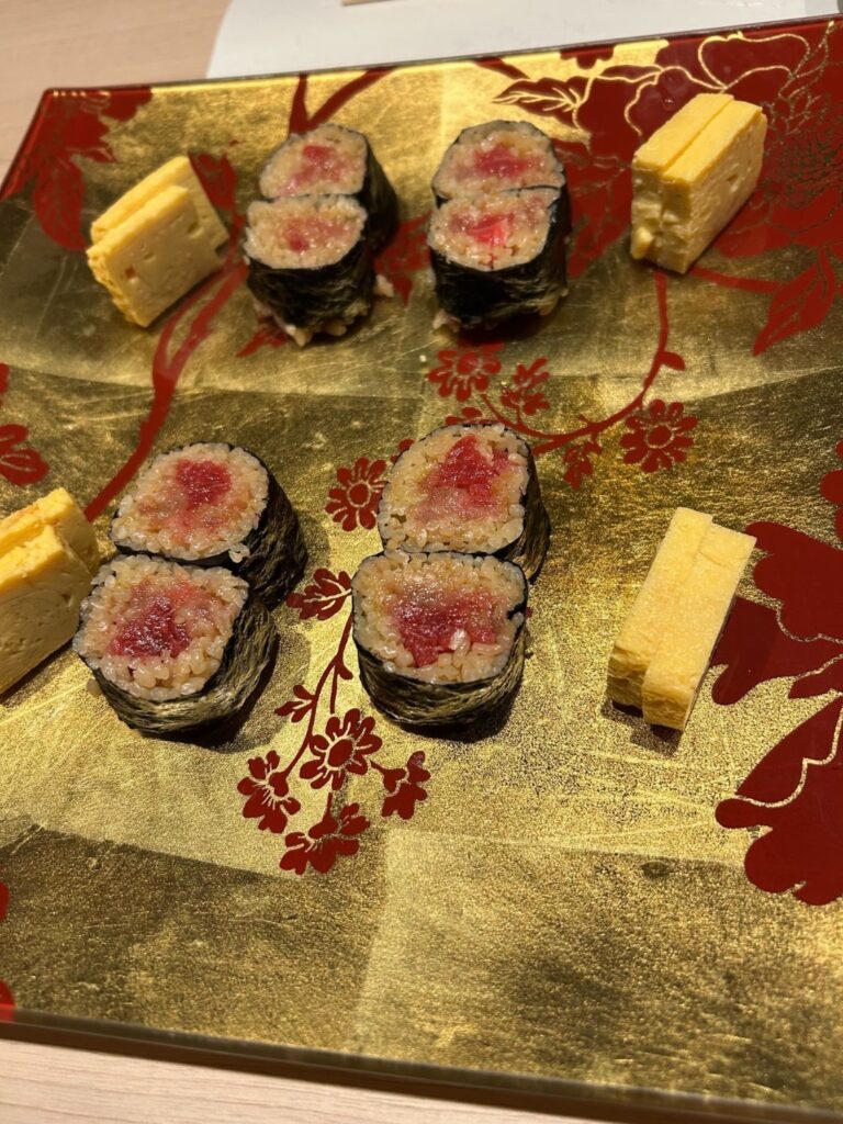 金と赤の花模様のお皿にのった鉄火巻きと玉子