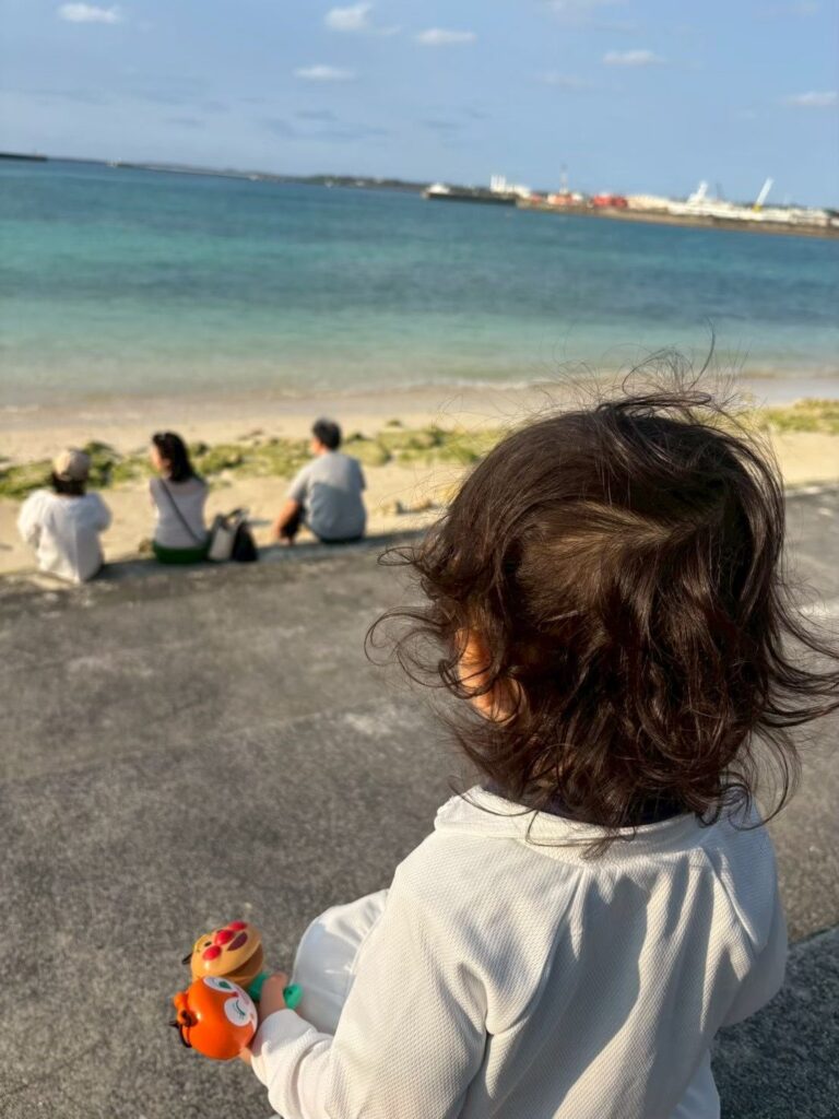 パイナガマビーチで海をながめる娘の後ろ姿